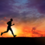 The silhouette of a man running in front of a sunset