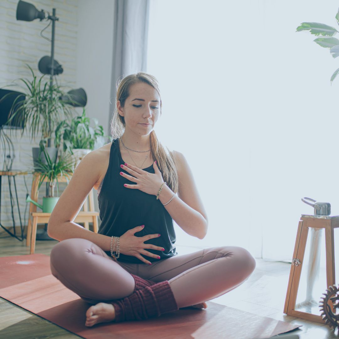 Young woman in a yoga studio practicing breathing techniques